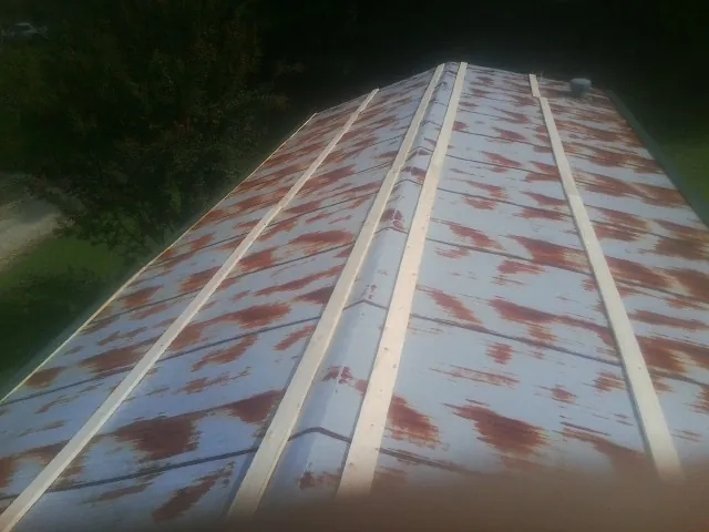 Rusted metal roof panels with new wood purlins before replacement — Storm Damage Roof Repair in Prattville by Roofing Brothers