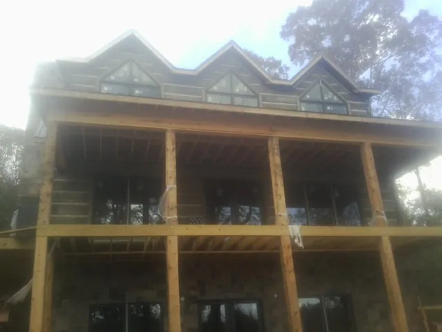 Dormers and porch framing on a large log home under construction — Roof Coating work by our crew in Prattville
