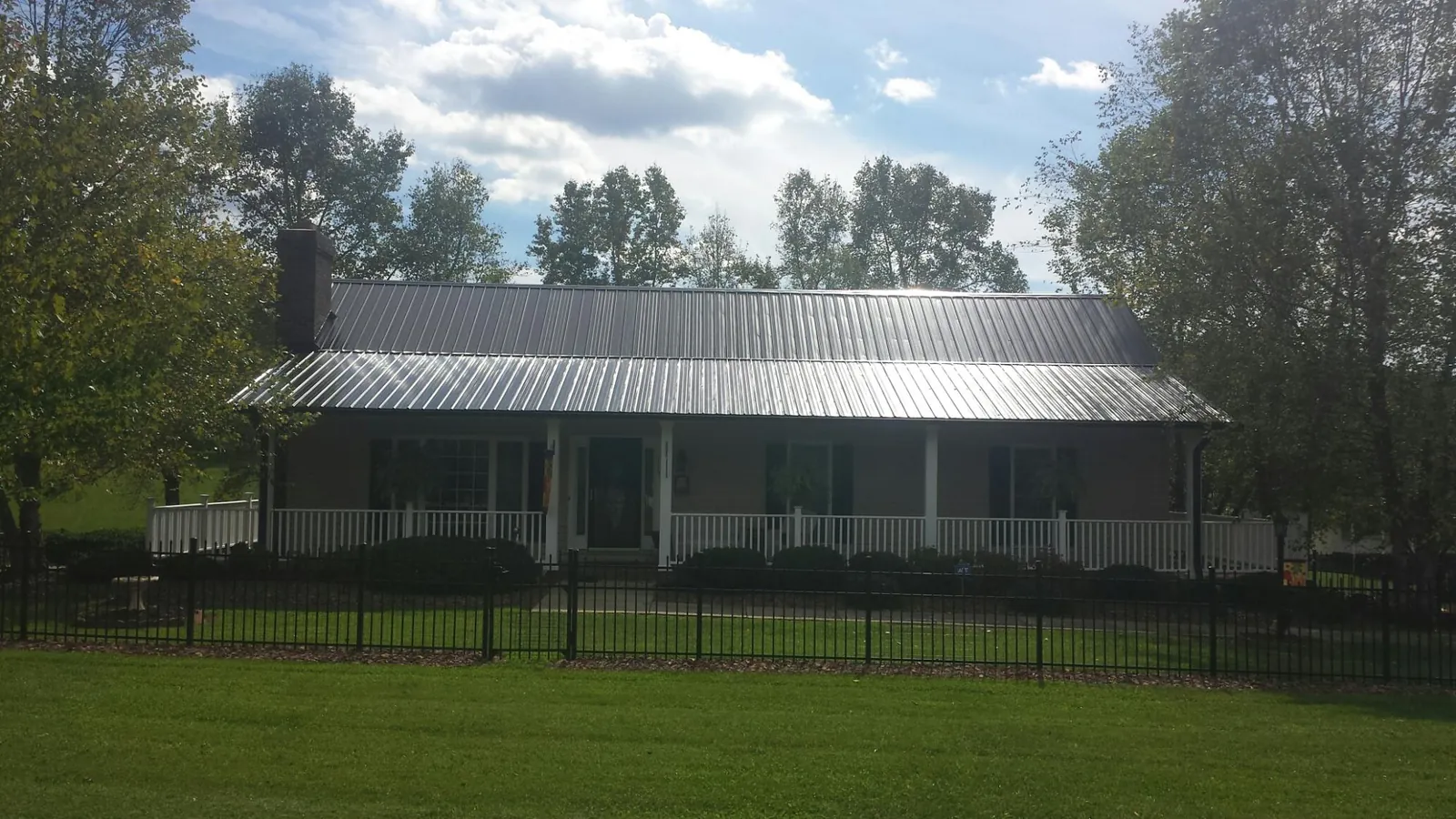 Gray metal roof on a brick ranch with a full width front porch — Gutter Guard Installation work by our crew in Prattville
