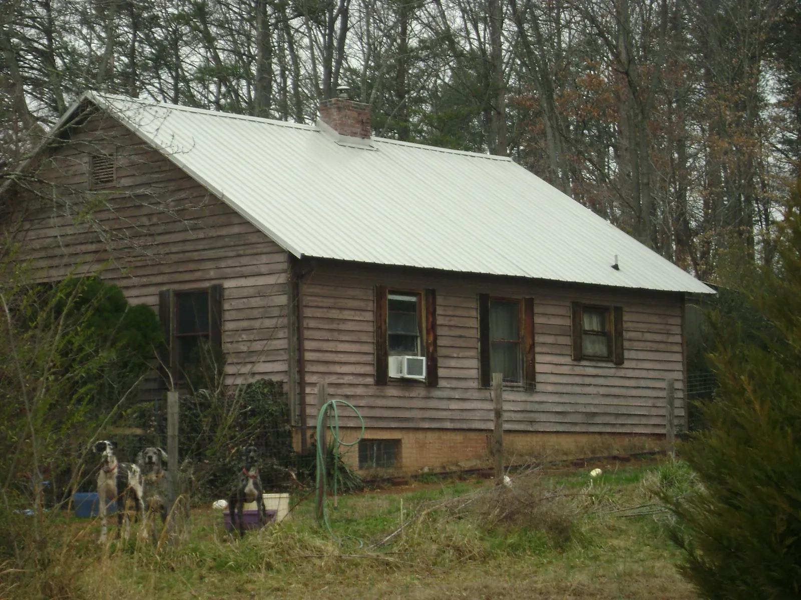 White metal roof on an old wood sided farmhouse, from a Metal Roof Installation job in Prattville